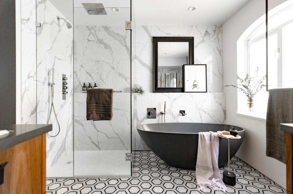 Black and white bathroom with deep tub and large shower.